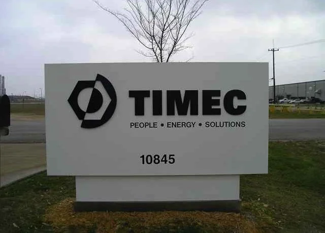 An outdoor business sign for TIMEC with the slogan 'People, Energy, Solutions' and the address 10845.