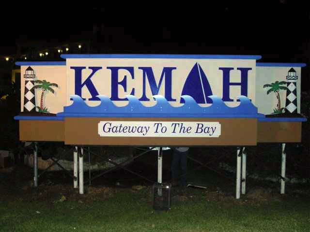 Large sign reading 'KEMAH' with a sailboat graphic, lighthouse, and palm trees, and text 'Gateway To The Bay' below.