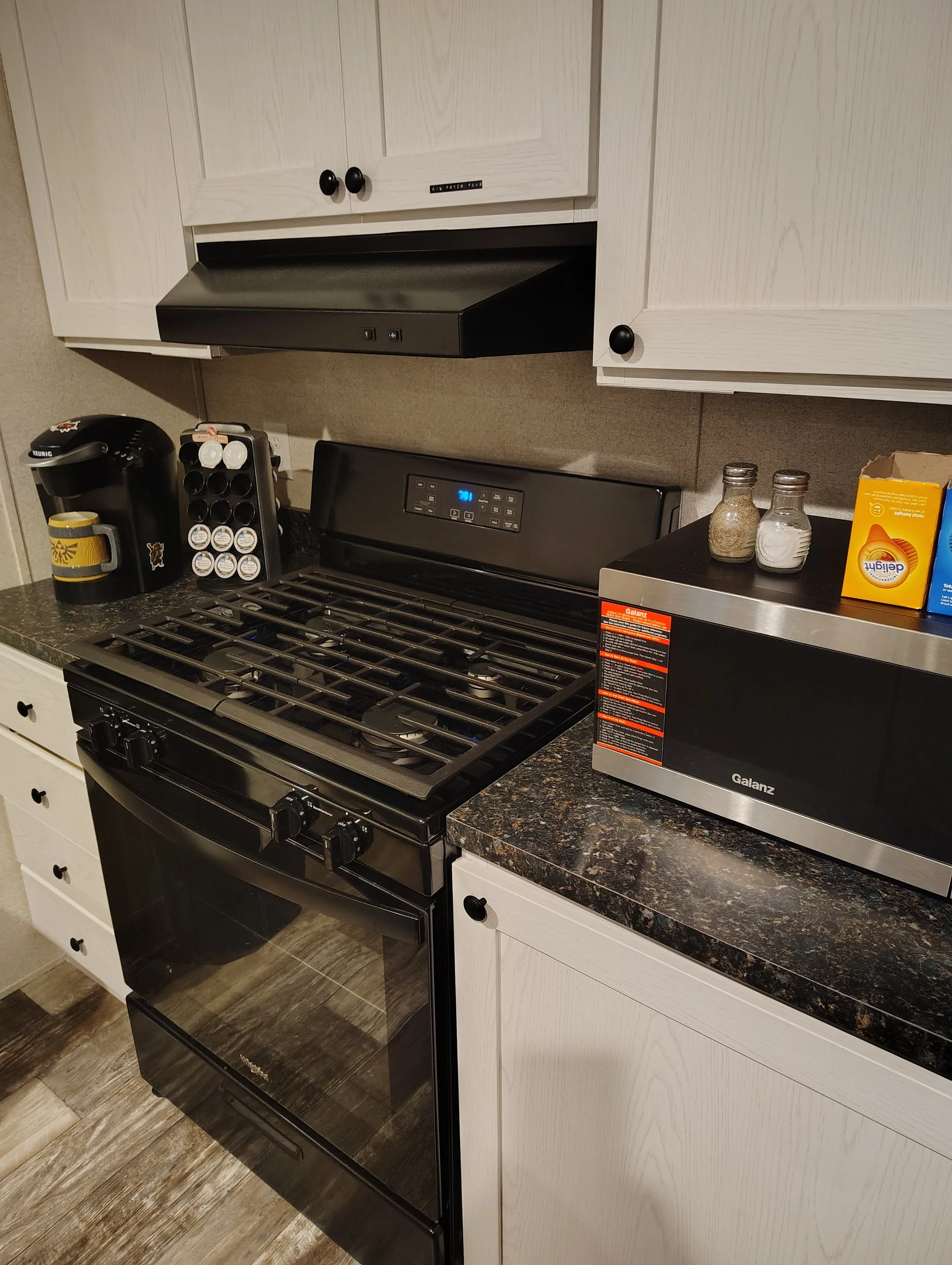 The kitchen has a microwave, oven/stove top, refrigerator, and coffee maker. 