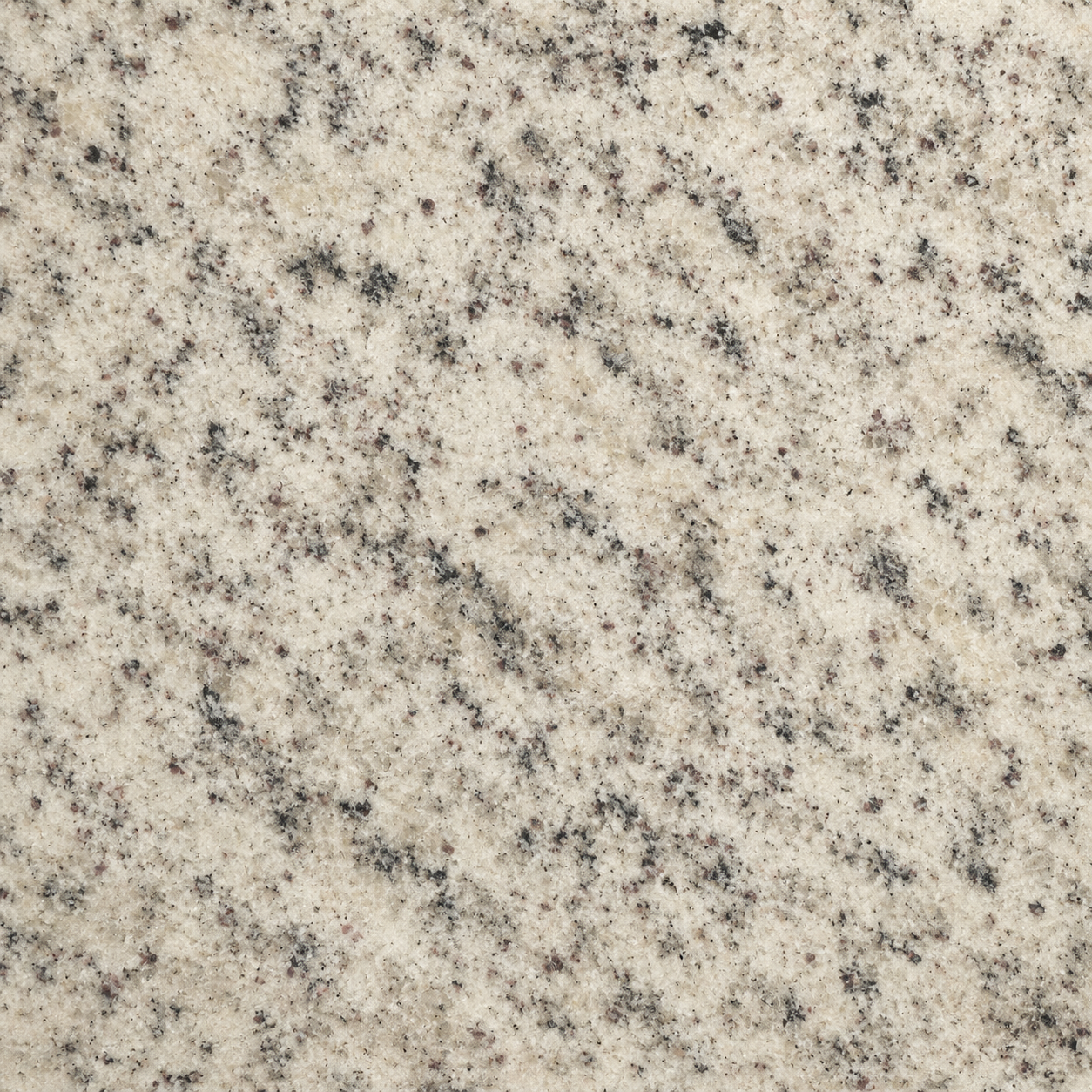 Superficie de piedra de granito con patrón de grano fino en tonos beige, negro y gris.