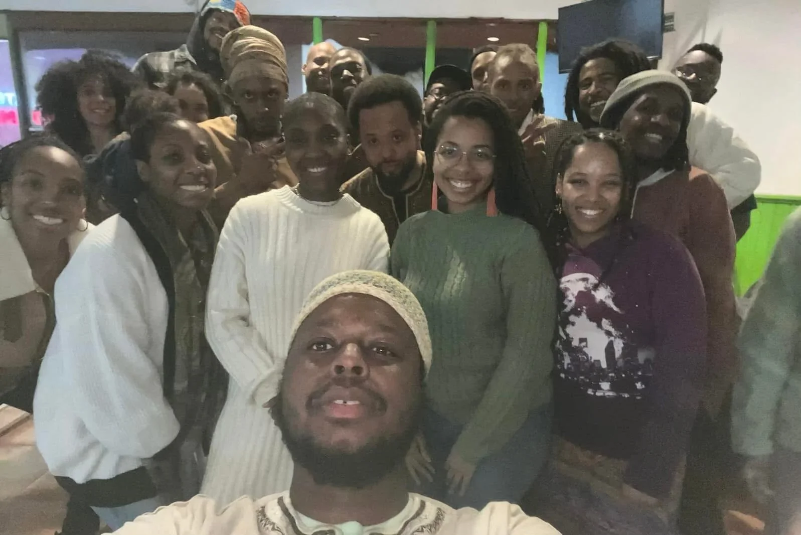 Group of Israelites smiling for a photo indoors, with some making peace signs. New Legacy Initiative. New Legacy, Inc.