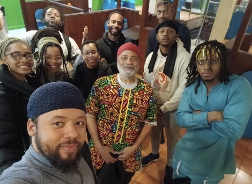 Group of nine people (Israelites) smiling and posing together indoors, with diverse clothing styles and hair types, some with glasses and locs. New Legacy Initiative. New Legacy, Inc.