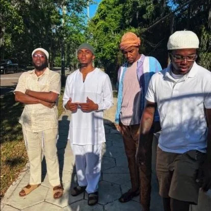 Four men (Israelites) walking outdoors on a sunny day in a green, wooded area. New Legacy Initiative. New Legacy, Inc.