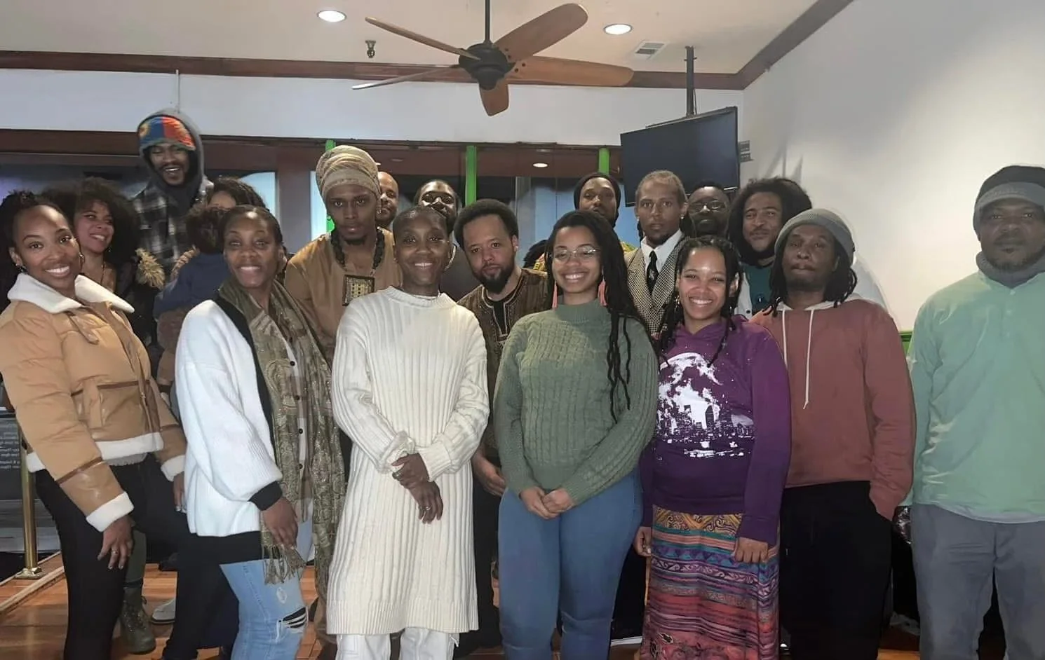 Group of diverse people (Israelites) gathered indoors, smiling for a group photo. New Legacy Initiative. New Legacy, Inc.