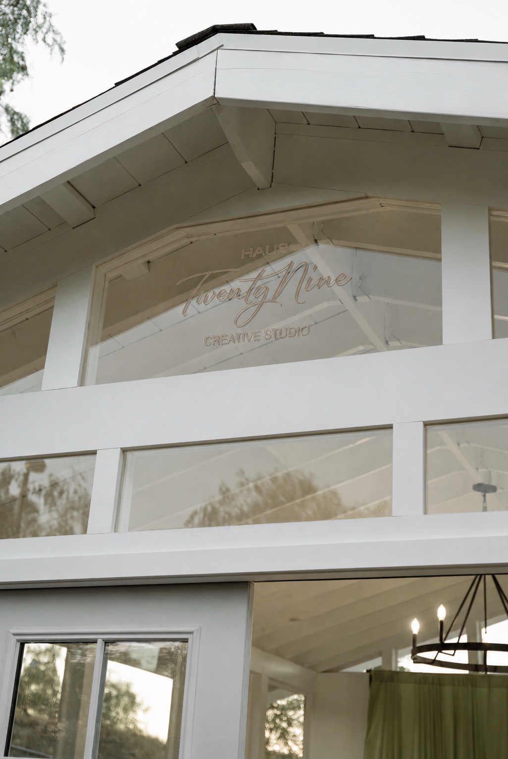 A modern white building with large windows and a sign for 'Twenty Nine Creative Studio' inside.