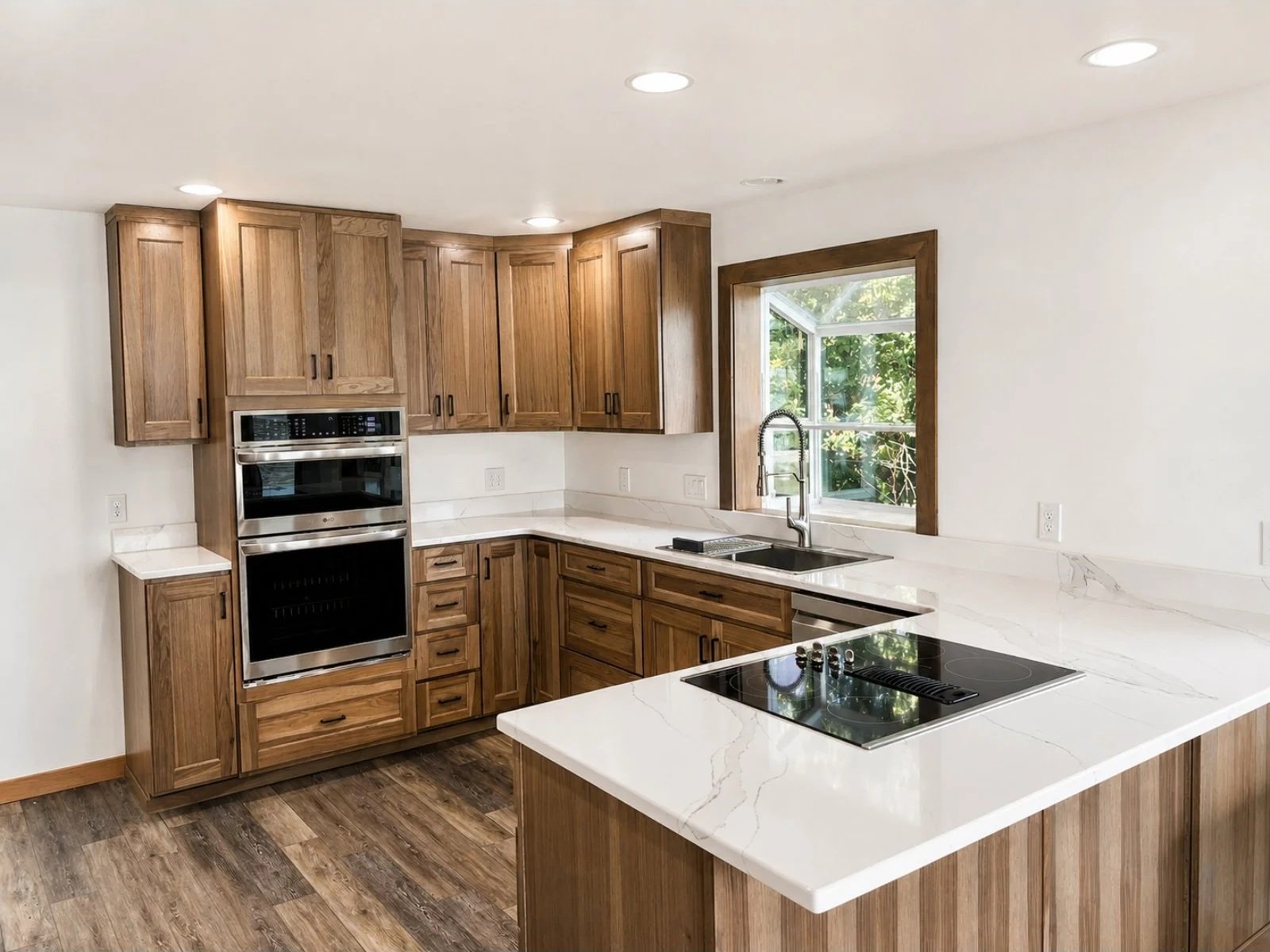 Kitchen with wooden cabinets, white marble countertops, a window above the sink, an electric cooktop on the island, and built-in stainless steel oven