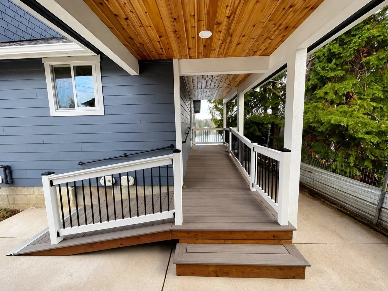 Newly built access ramp and wrap around porch with composite decking and new railing. 