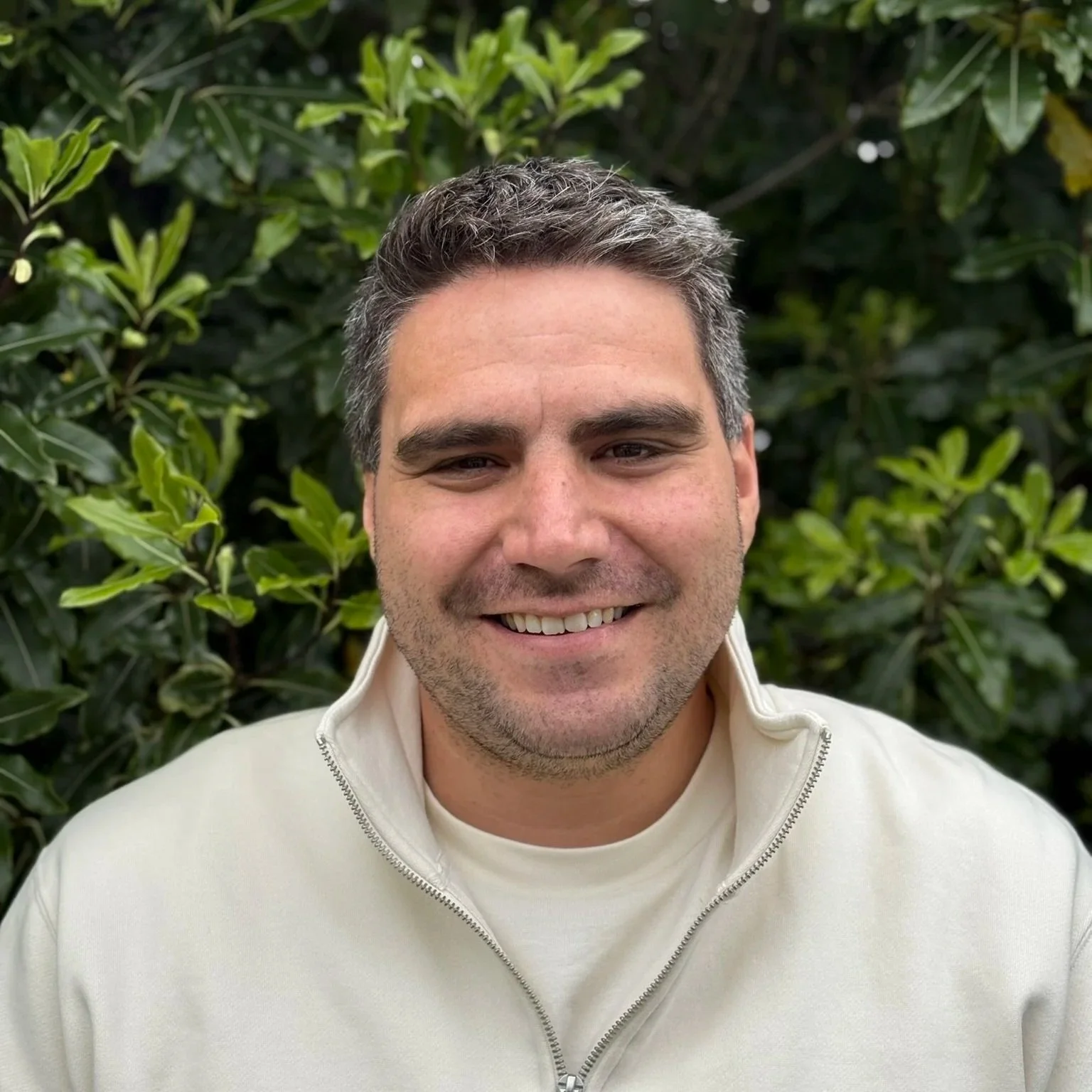 Headshot of smiling male tutor with medium-length black hair wearing a lanyard.