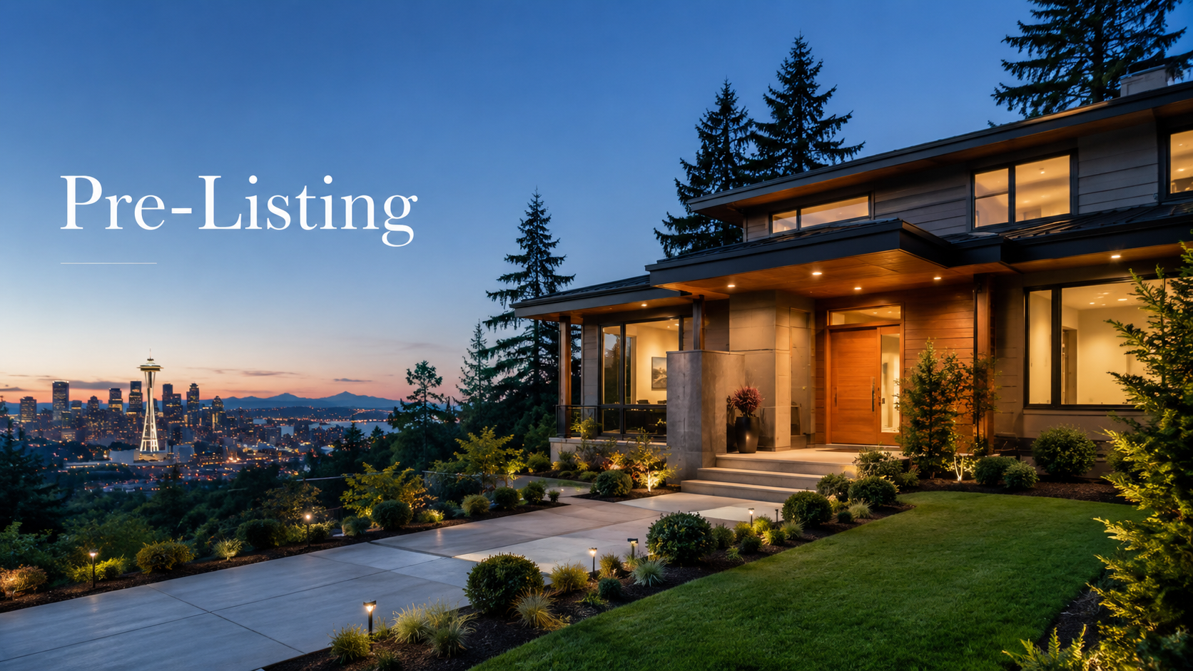 A modern house with lit interior windows and a landscaped front yard with small plants, shrubs, and pathway lights, overlooking Seattle skyline with the Space Needle at dusk.