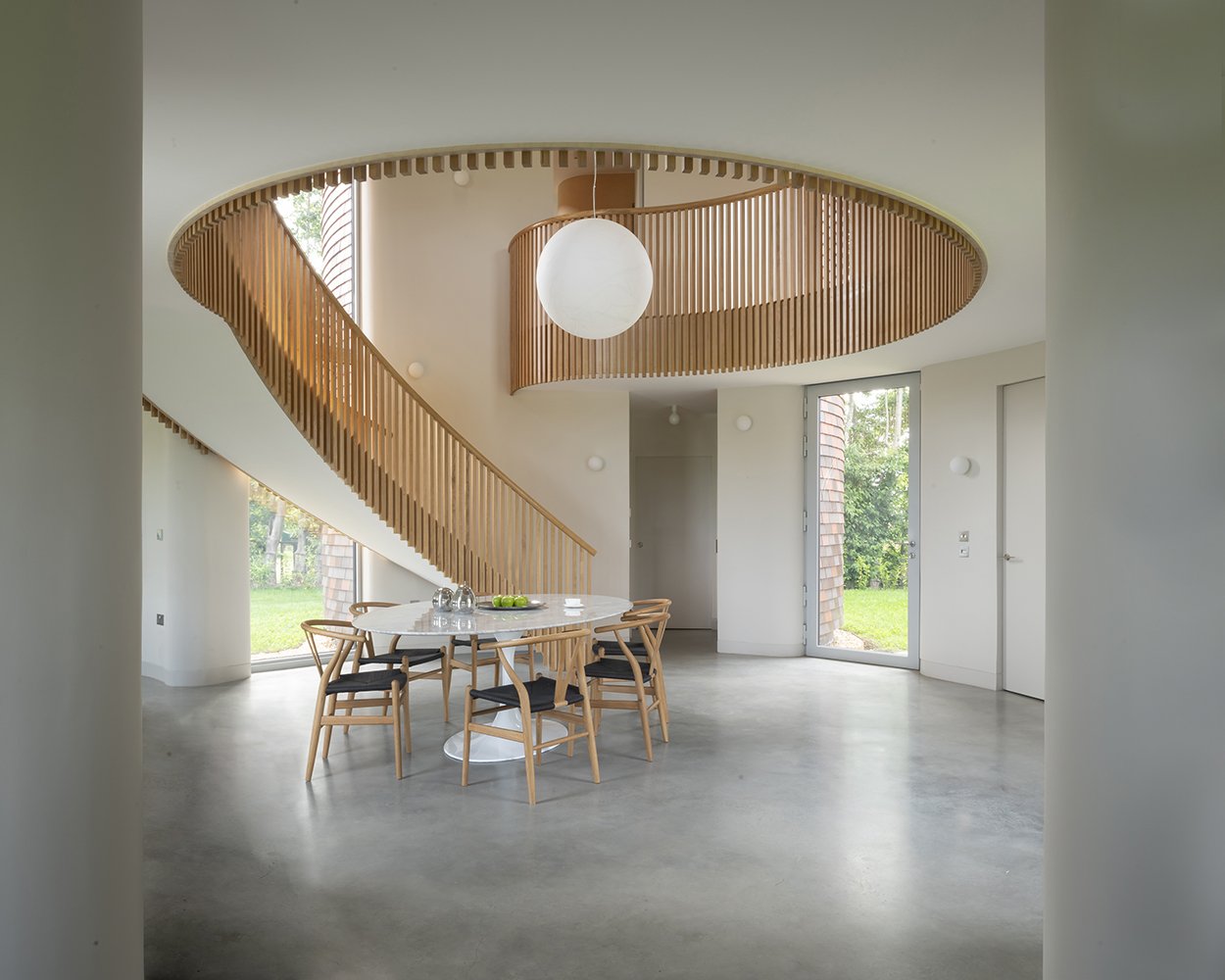 Interior view of dining space in triple height atrium, central to the home