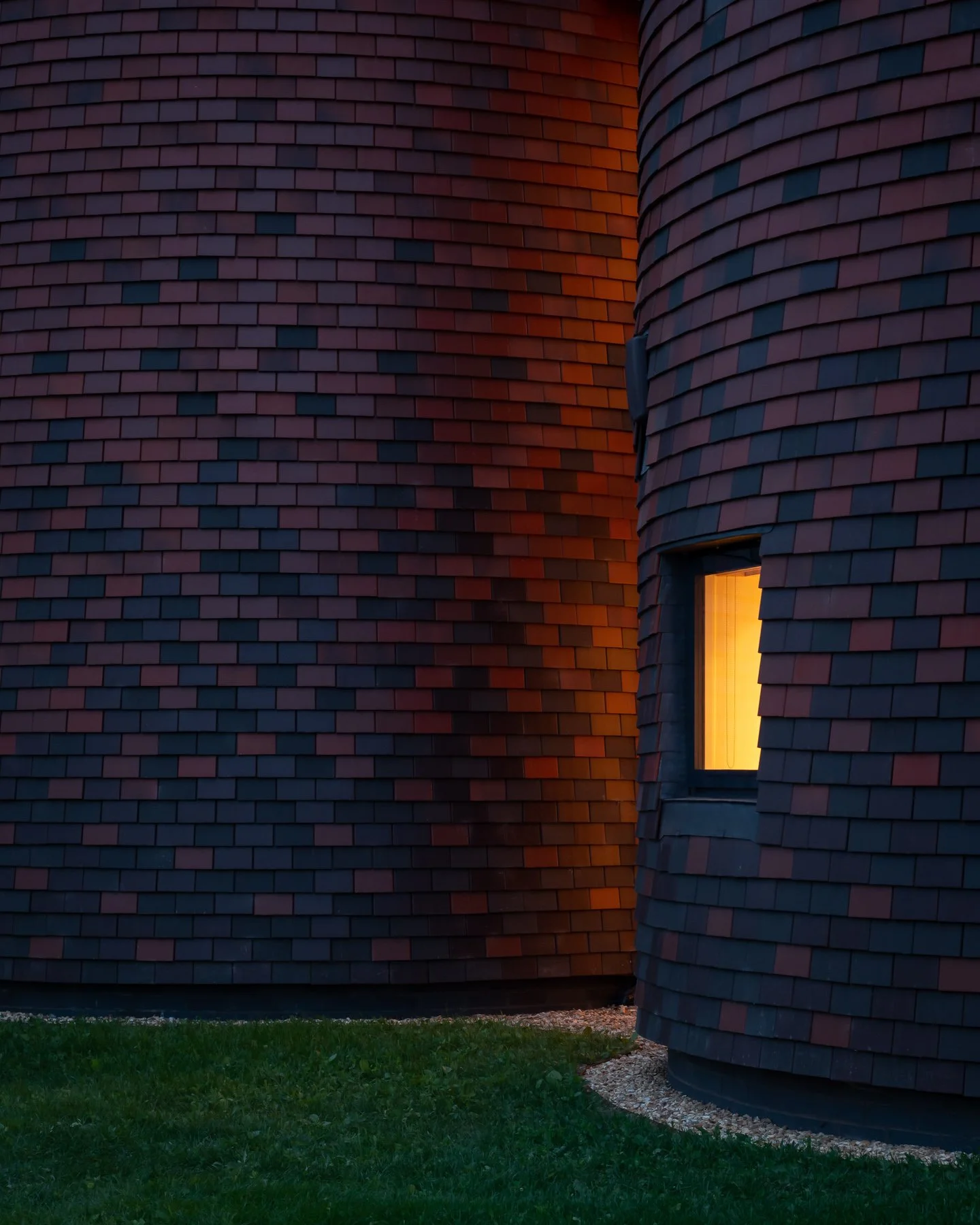 Bumpers Oast, Lucy Moroney Project Architect, exterior view of intersecting cones with warm glow light coming from the interior spaces