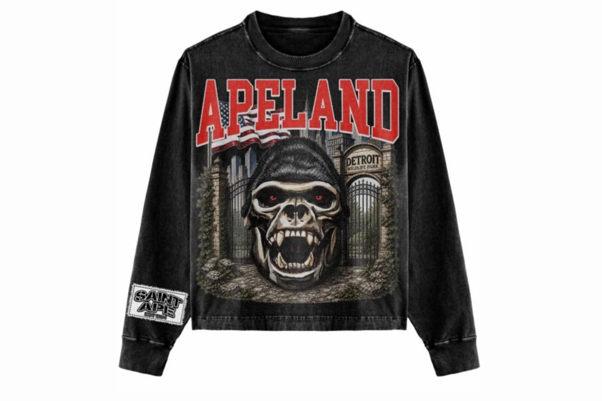 Black long-sleeve shirt with a graphic of a scary gorilla face, the word 'APELAND' in large red letters, and a background with a gate and trees, referencing Detroit Wildlife Park.