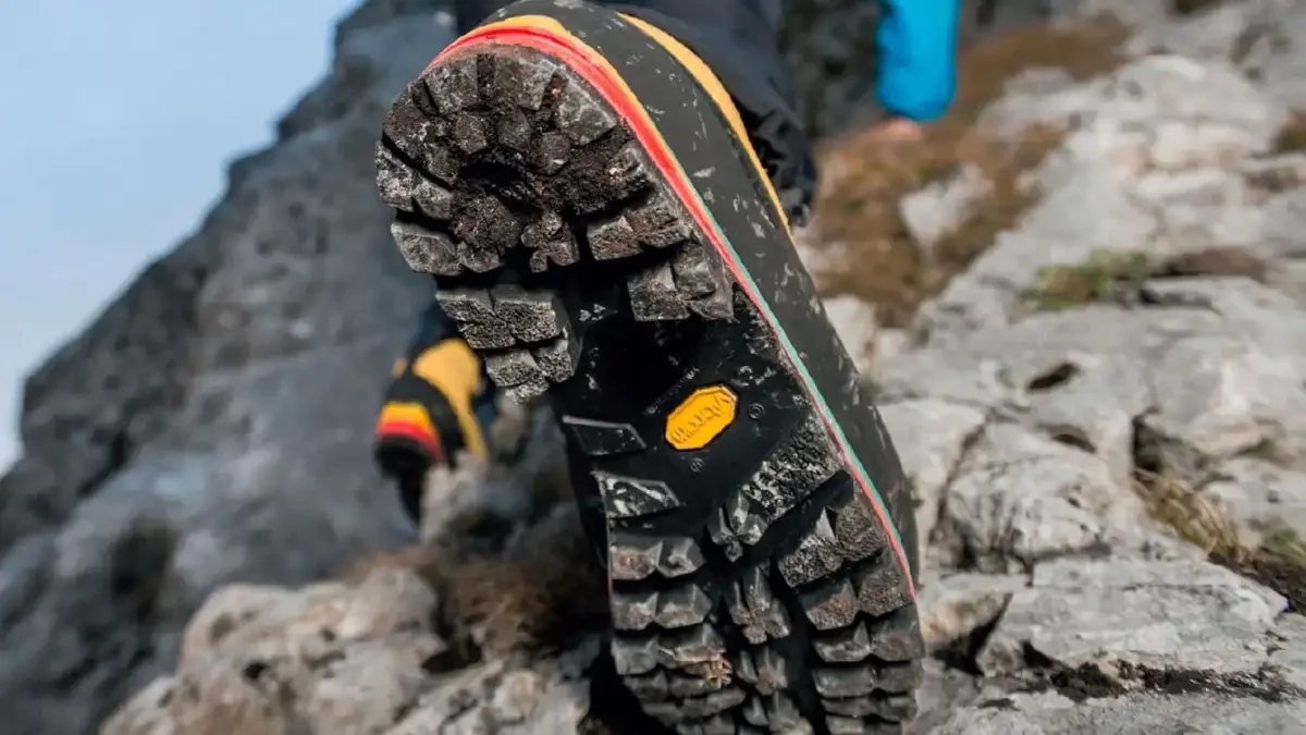 Close-up of a rugged hiking boot on a rocky mountain trail.