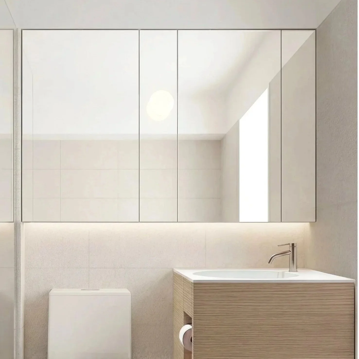 Modern bathroom with a large mirror, white tiled wall, a small vanity with a sink and faucet, a toilet, and a window letting in natural light.