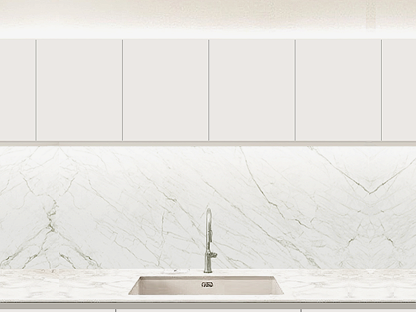 Close-up view of a modern kitchen with white marble backsplash and countertop, and light-colored upper cabinets.