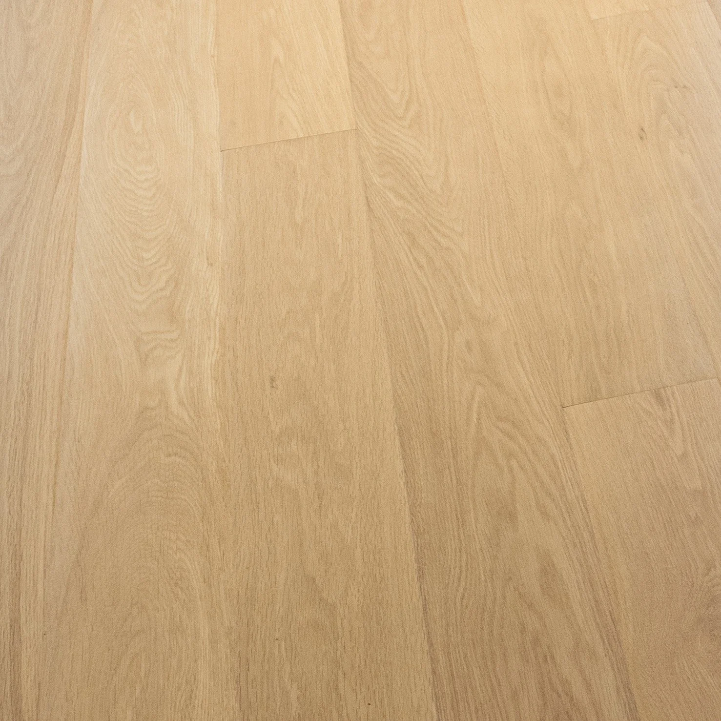 Close-up view of a light-colored wooden floor with visible grain patterns.