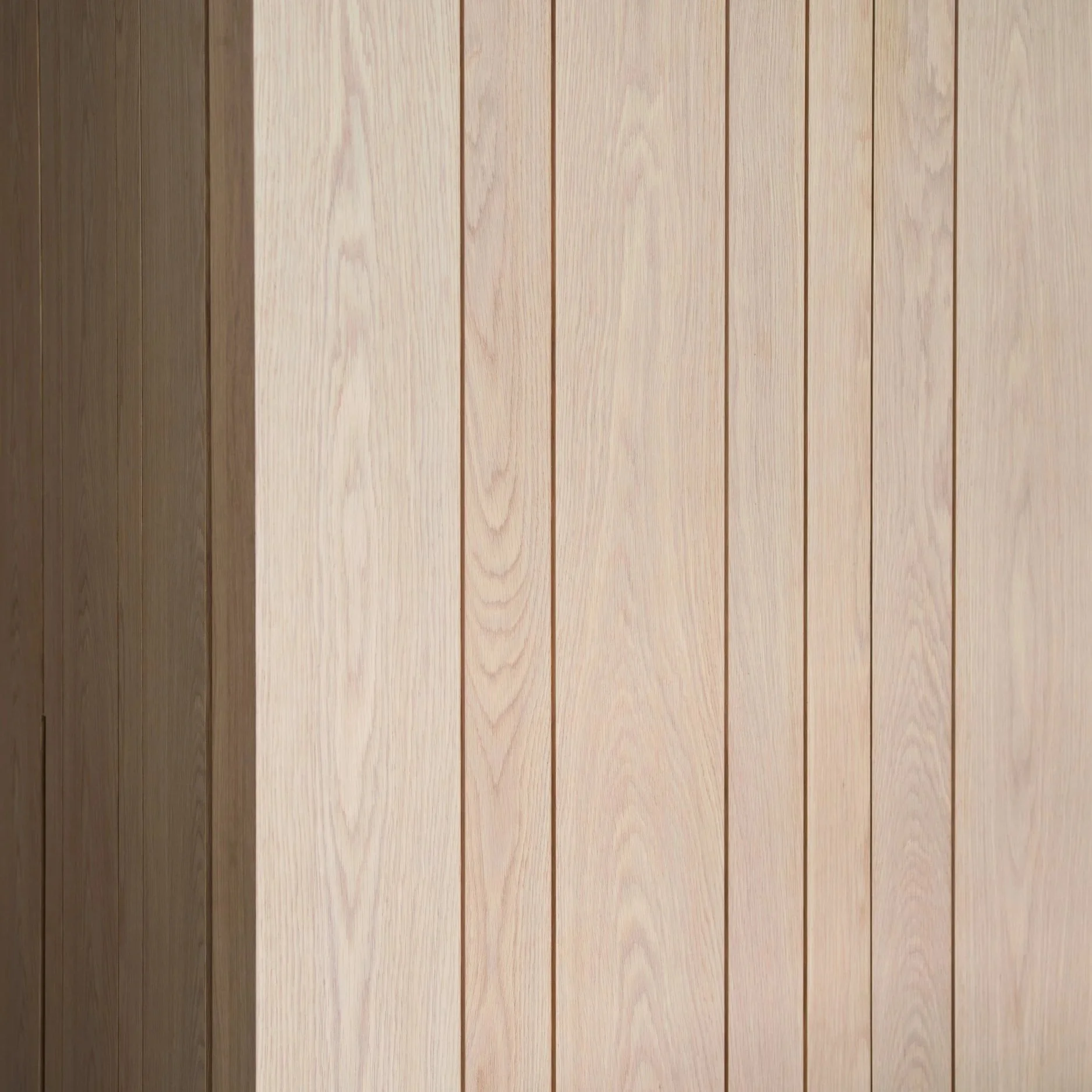 Light-colored wooden wall panels with vertical grooves.