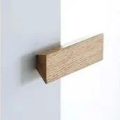 Wooden door handle attached to a white wall