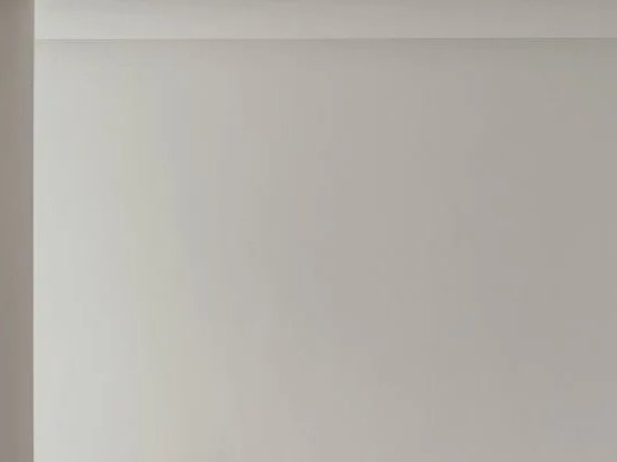 Empty white wall with a corner and a gray ceiling.