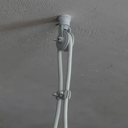 A close-up of a ceiling hook with two white cables or wires hanging from it.