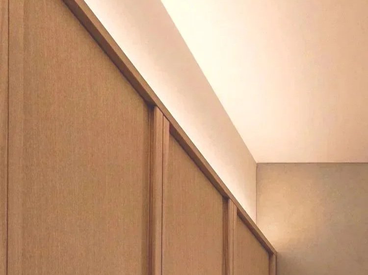 View of a beige sliding closet door and a white ceiling in a room.