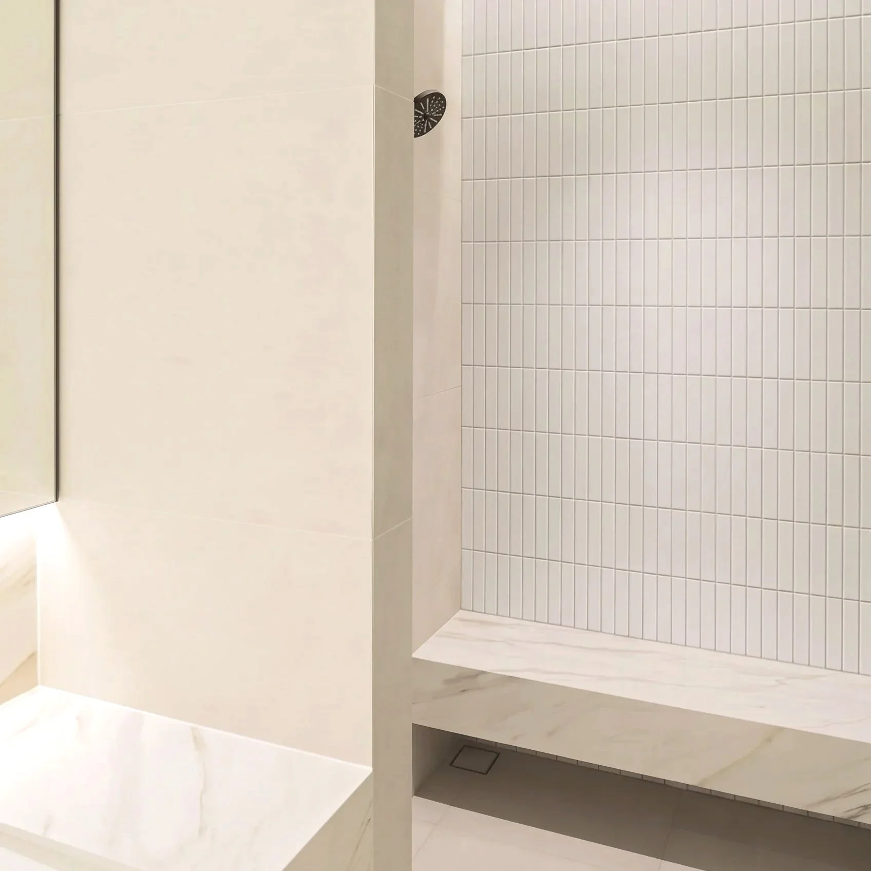A bathroom with a walk-in shower featuring white square tiles and a black showerhead.