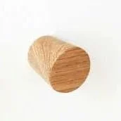 Wooden cylindrical object, possibly a small container or spool, on a white background.