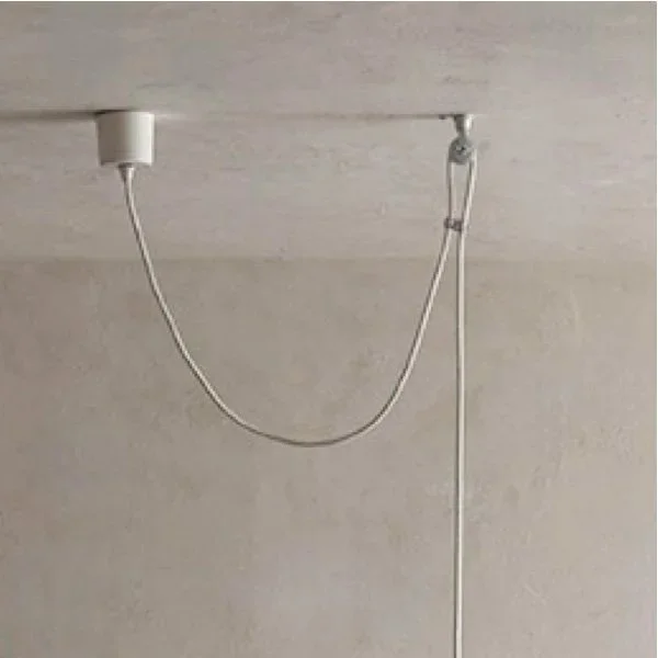 A ceiling-mounted smoke detector connected to a ceiling and wall with a white wire hanging down.