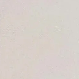 A plain white wall with minor imperfections and texture.