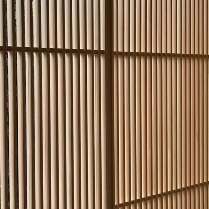 Close-up of beige wooden slats arranged vertically as a decorative partition or wall.