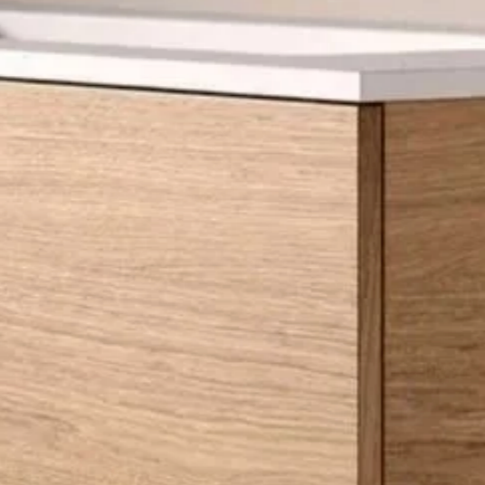 Close-up of a light wood dresser with a white top.
