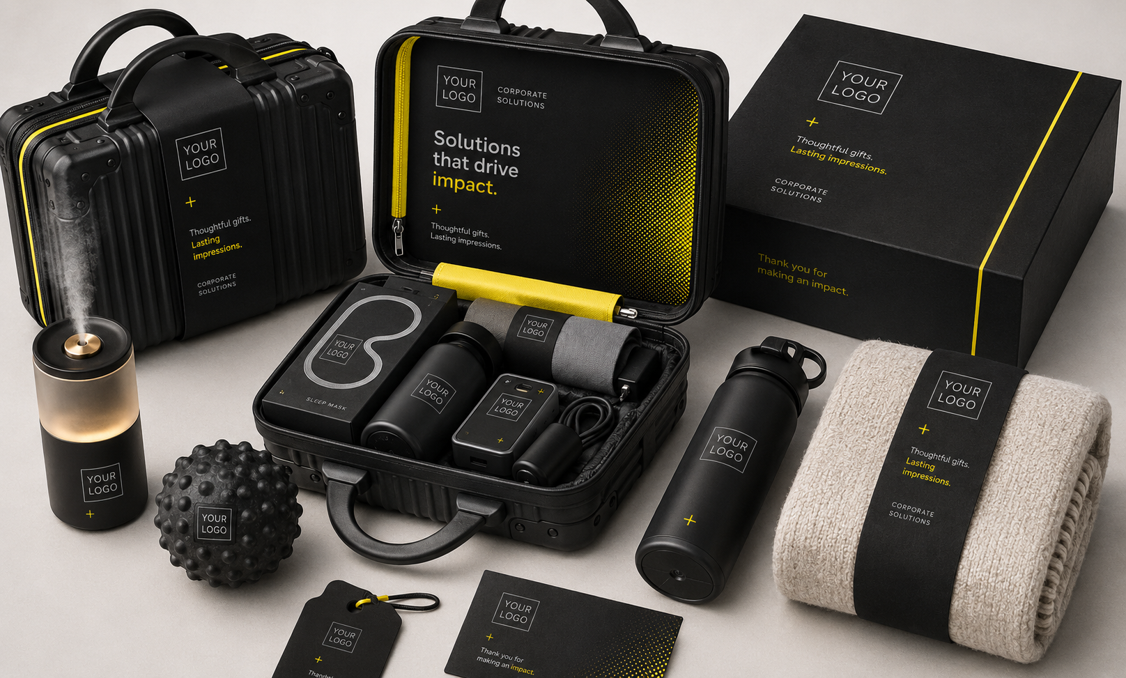 A set of corporate gifts and accessories with customizable branding, including a black briefcase, a black hard case, a black box, a black tumbler, a black diffuser, a textured massage ball, a sleep mask, a blanket, and promotional cards, all featuring placeholder logos and yellow accents.