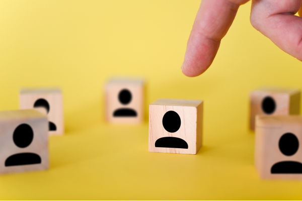 finger points to person block. Other same blocks surround. Yellow background