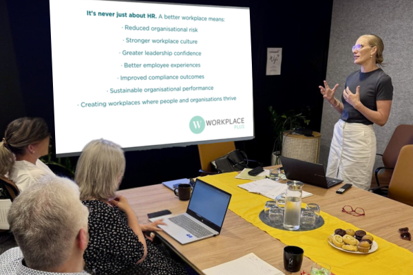 board meeting with slideshow. CEO presenting with hard gesture. yellow table runner.