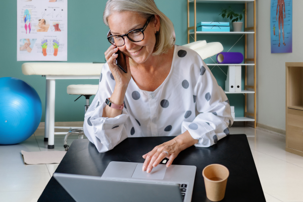 Allied health practice owner at her desk on the phone.