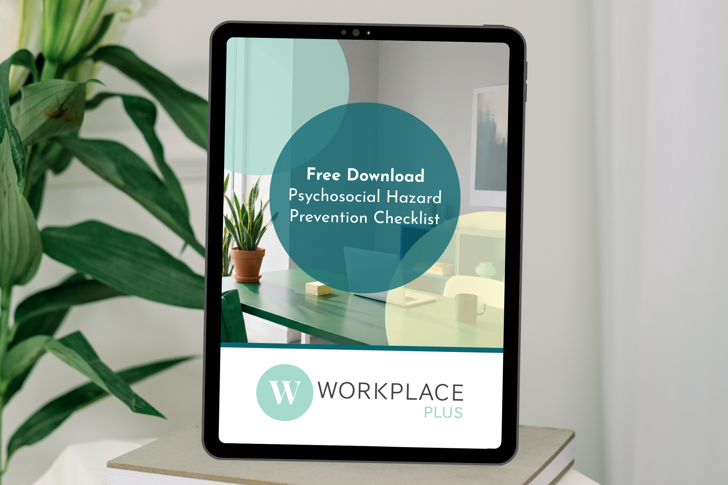 Tablet screen displaying a free downloadable document titled 'Psychosocial Hazard Prevention Checklist,' with a background image of a modern office interior featuring a desk, chair, and potted plant.