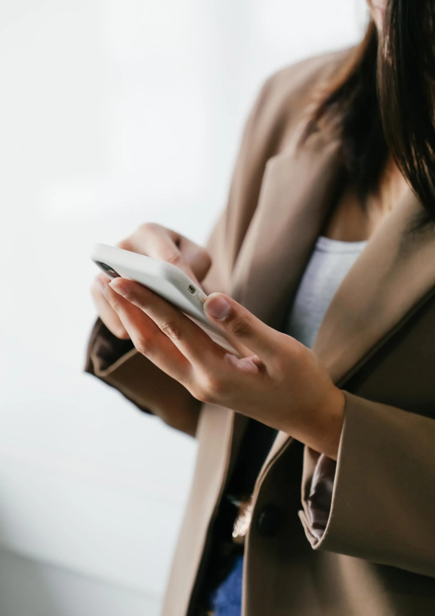 A person sitting on a bench, holding a smartphone in one hand.