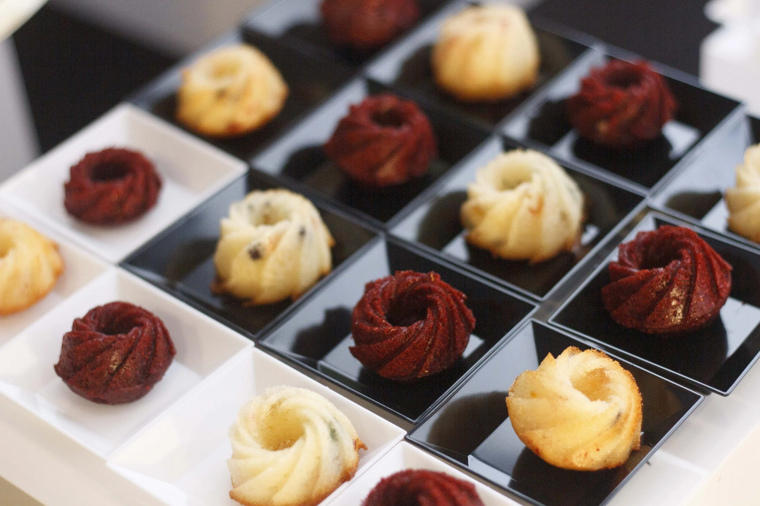 Un assortiment de muffins aux myrtilles, pommes, betteraves et autres saveurs dans un plateau de présentation.