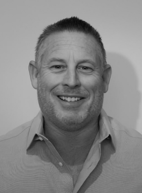 Black and white portrait of a smiling man wearing a collared shirt.
