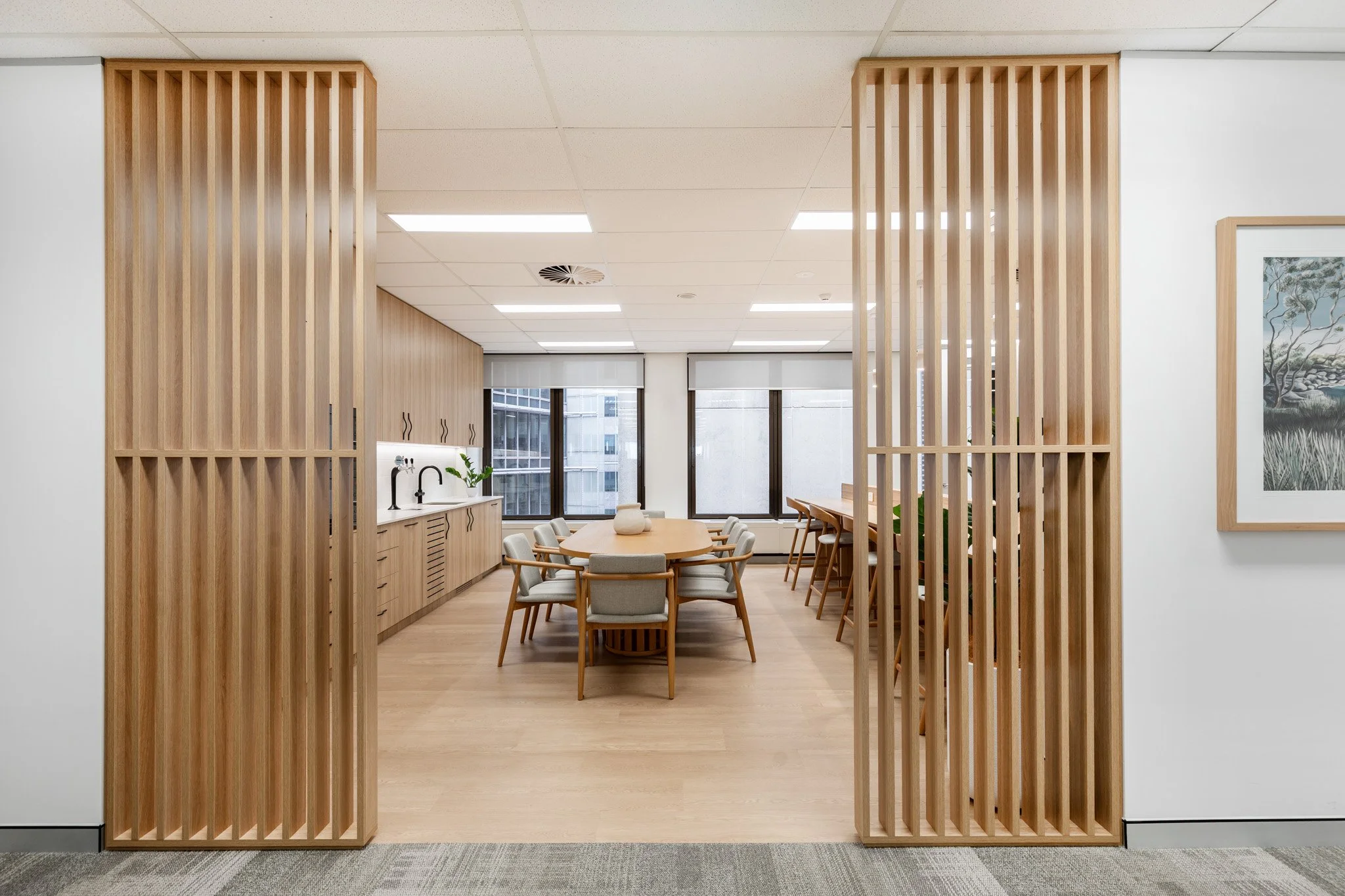 Conference room with wooden partitions, a wooden table, chairs, and large windows.
