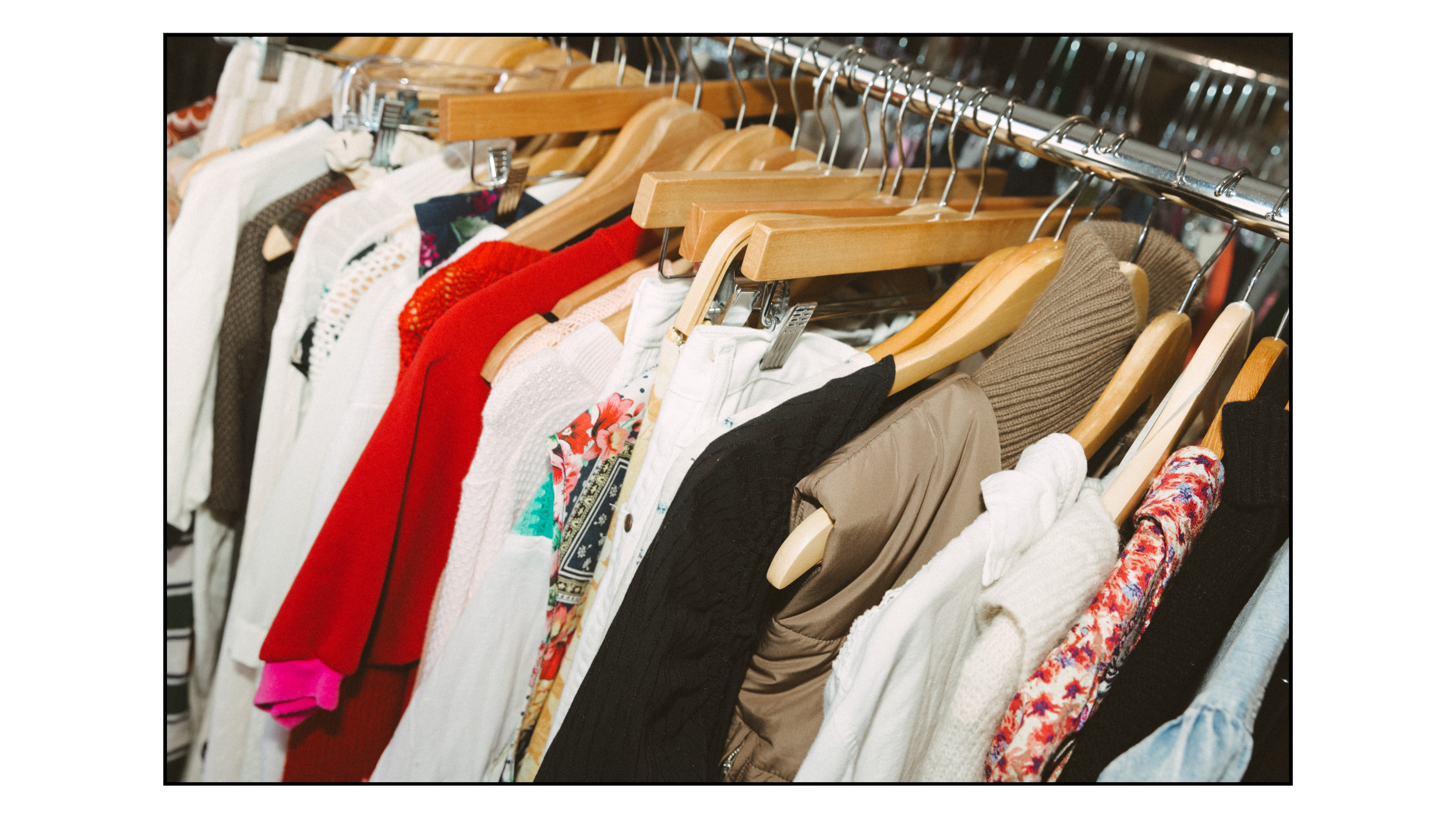 Clothes hanging on a rack in a store, including various shirts and jackets in different colors and patterns.