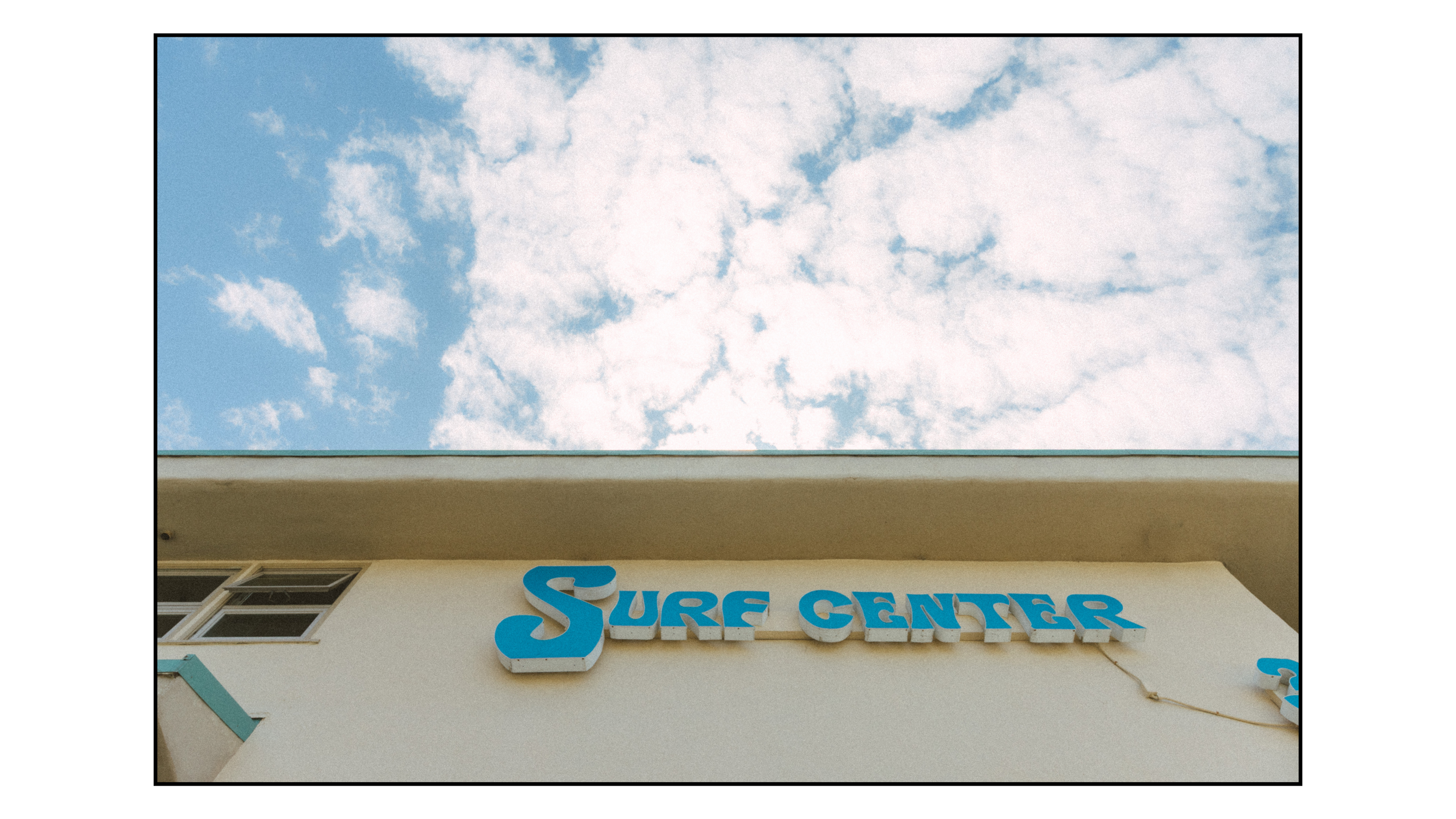 Photo of a building with a sign that reads 'Sure Center' and a partly cloudy sky above.