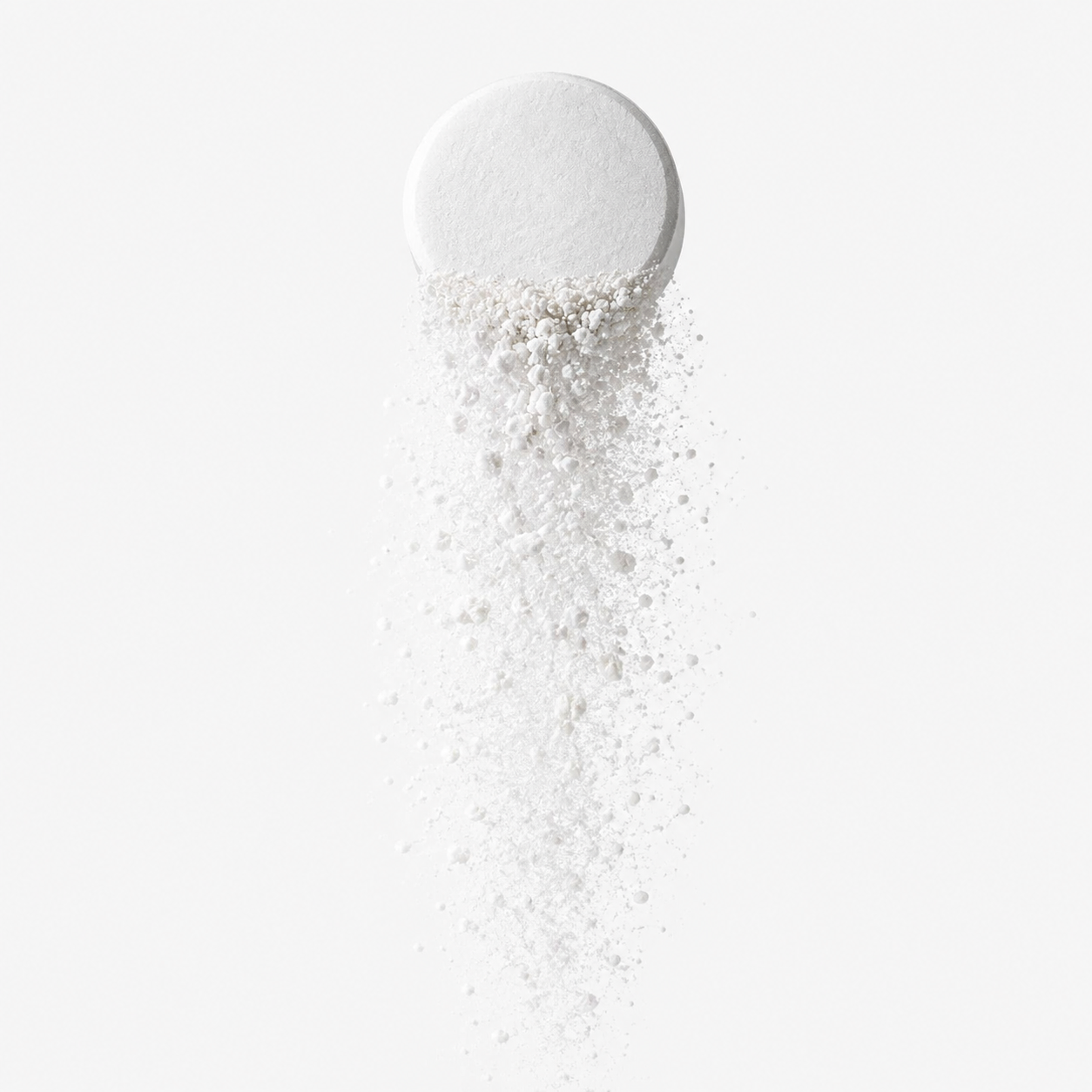 A white, round tablet with some powdered substance spilling downward onto a white surface.