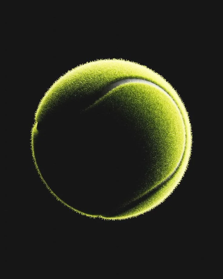 Close-up of a green tennis ball on a black background.