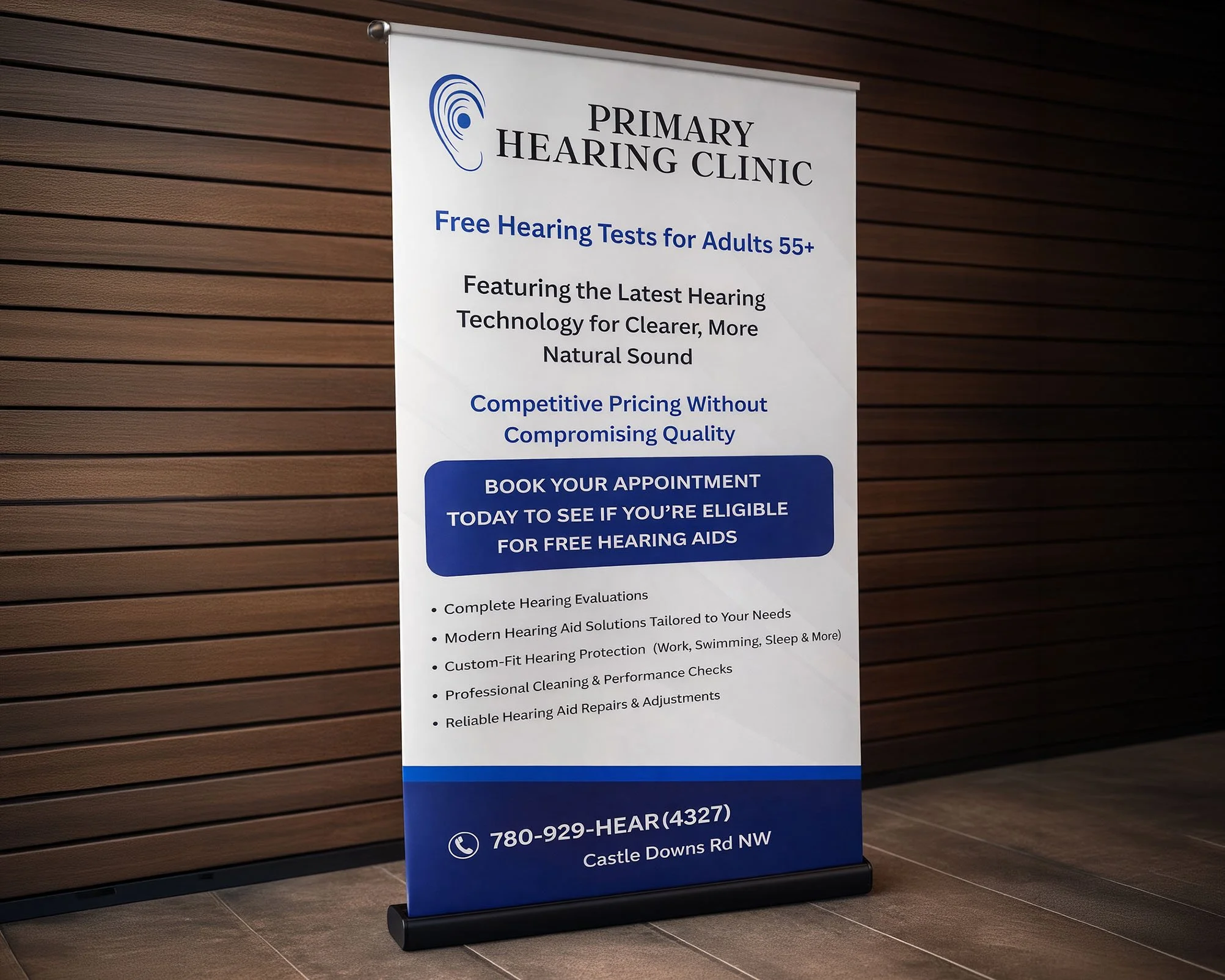 Sign for a primary hearing clinic offering free hearing tests for adults 55 and older, featuring hearing technology, competitive pricing, and free hearing aids eligibility. The sign includes contact information and location details.