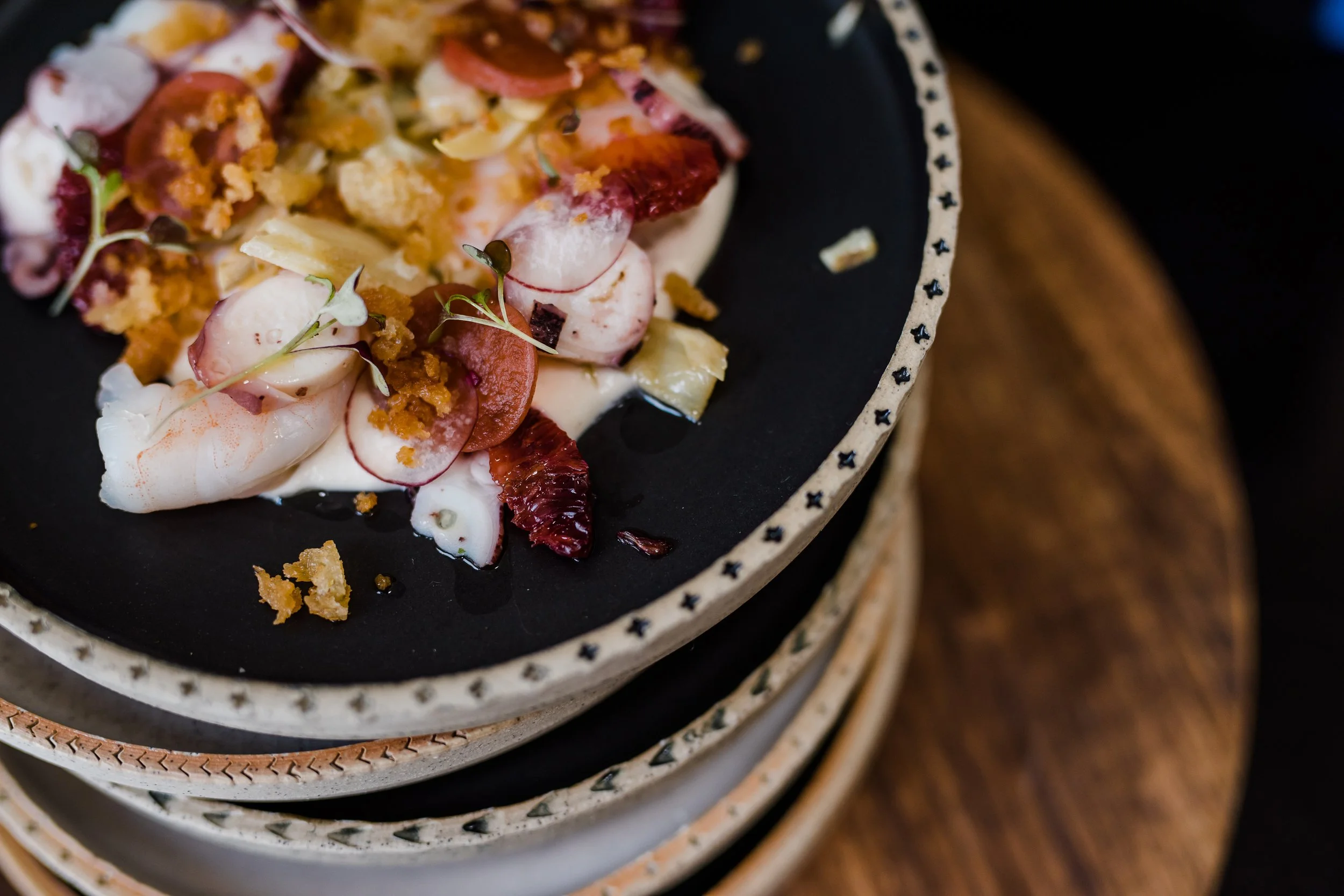 Editorial hospitality photography of a chef-prepared seafood dish photographed for restaurant marketing and menus.