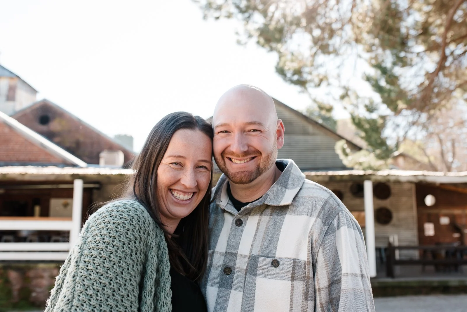 Mother and father together outside in a relaxed portrait.