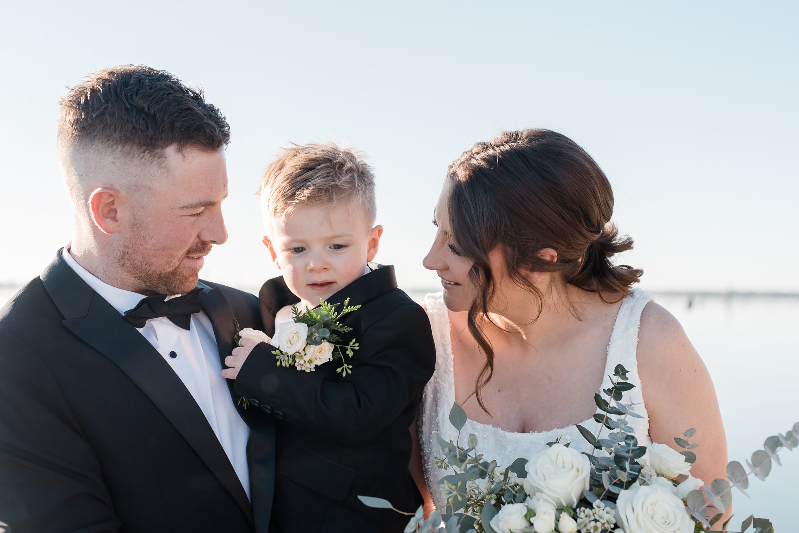Bride and groom sharing a quiet moment with their young son during their intimate wedding celebration in Yarrawonga regional Victoria.