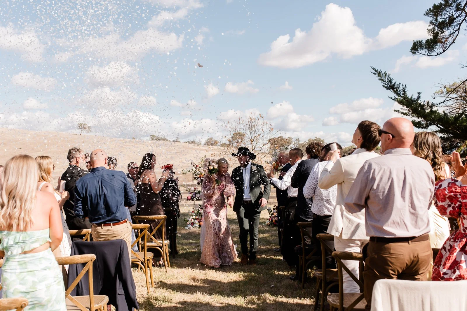 Guests shower a newly married couple with confetti after an intimate outdoor wedding ceremony in regional Victoria.