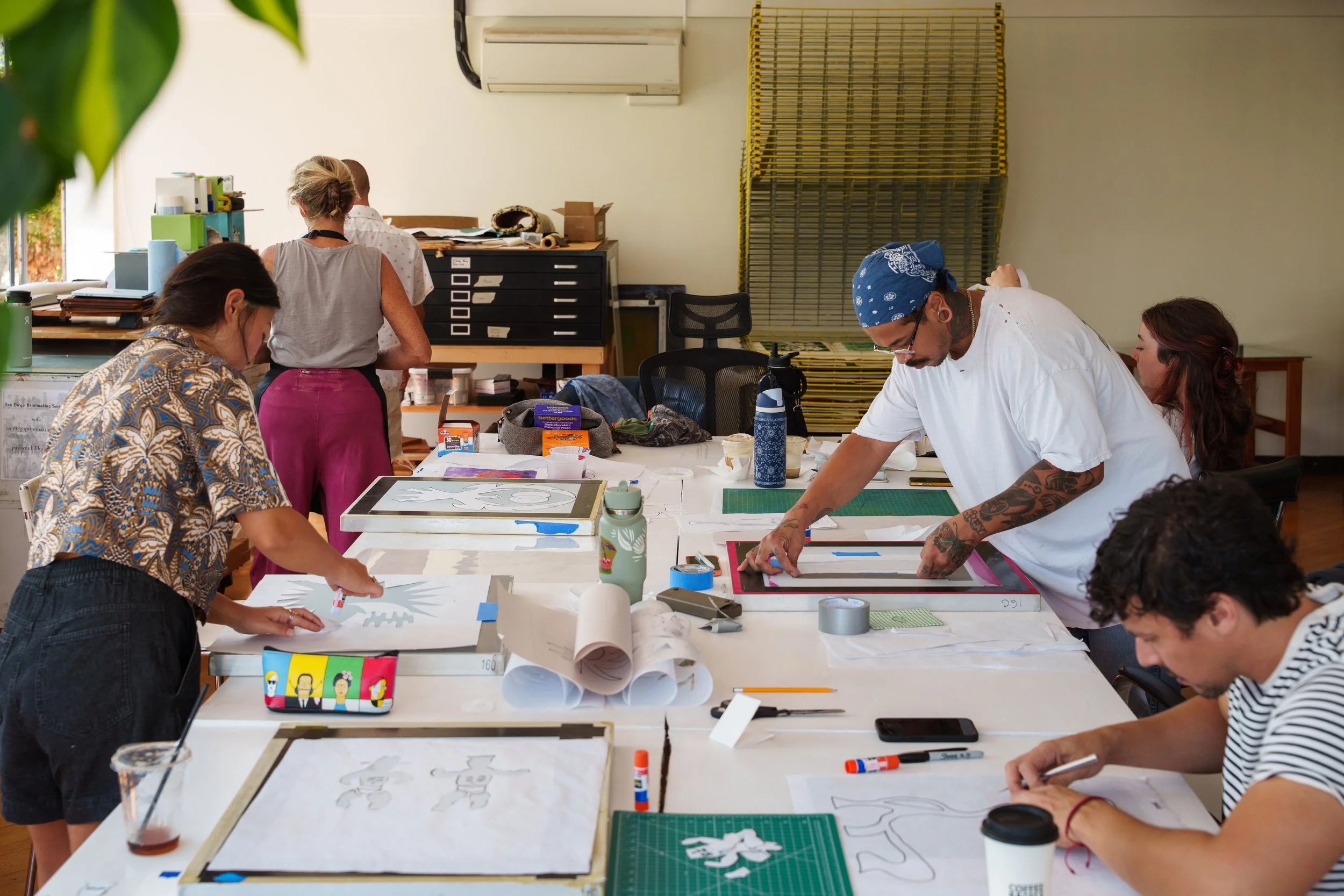 Students work around a table in the print studio.